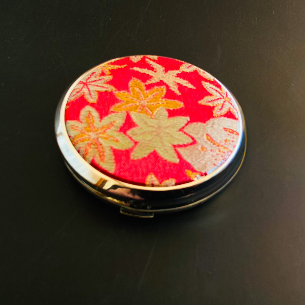 Vintage Nishijin compact by ELEGANT TOKYO, circa 1975–1990, with vermilion silk and woven maple leaf patterns.