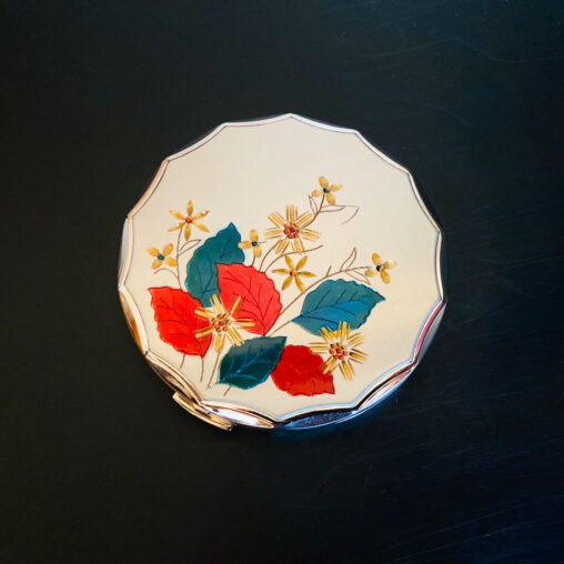Crown compact with floral motif featuring red and green leaves and gold flowers on a cream enamel base (Showa era, 1950s–60s)