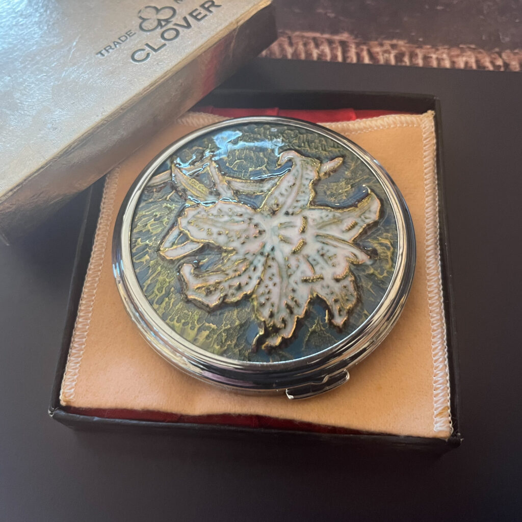 光を受けて釉薬の層が浮かび上がる七宝百合文コンパクト