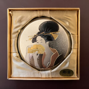 Showa-period chokin metal compact featuring an engraved bijin holding a folding fan